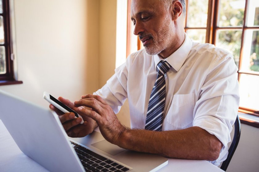 An agent comparing carrier quotes on a laptop and phone