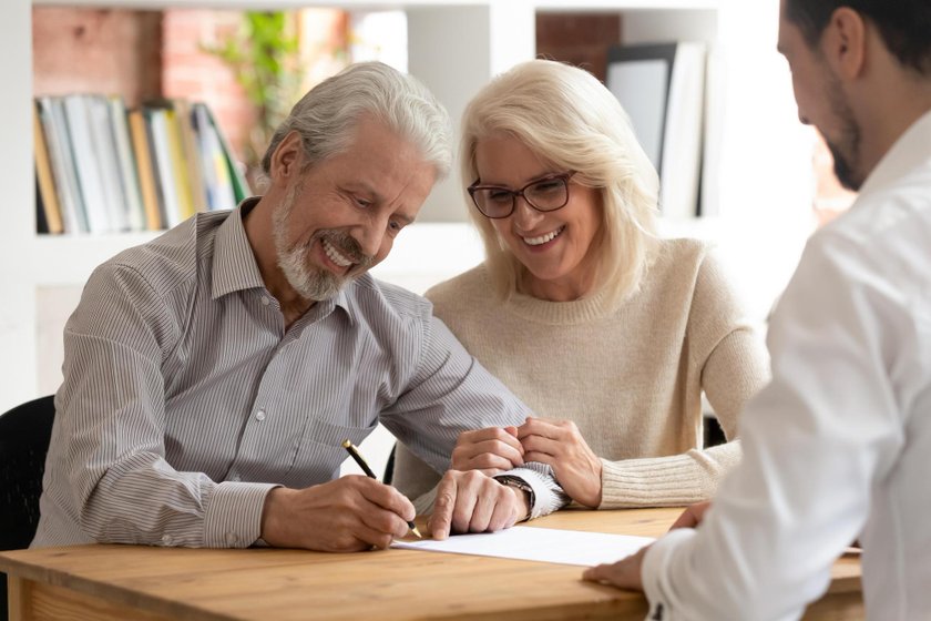 A couple choosing and signing the policy that fits them with their agent